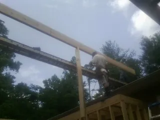 Carpenter setting a ridge beam over a new addition frame — Ice Dam Removal by Roofing Brothers in Ocean Shores