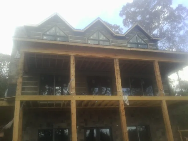 Dormers and porch framing on a large log home under construction — Roof Coating work by our crew in Ocean Shores
